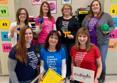 Group of women teachers wearing Mathgals Tshirts holding signs that say MathGals